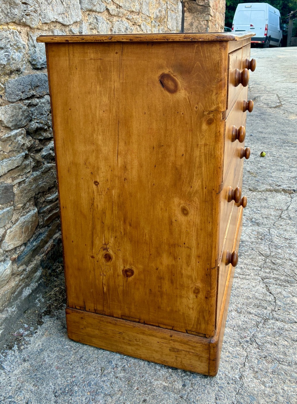 A Victorian pine chest of drawers featuring a two short over three long drawer arrangement with turned wooden knobs. View IV