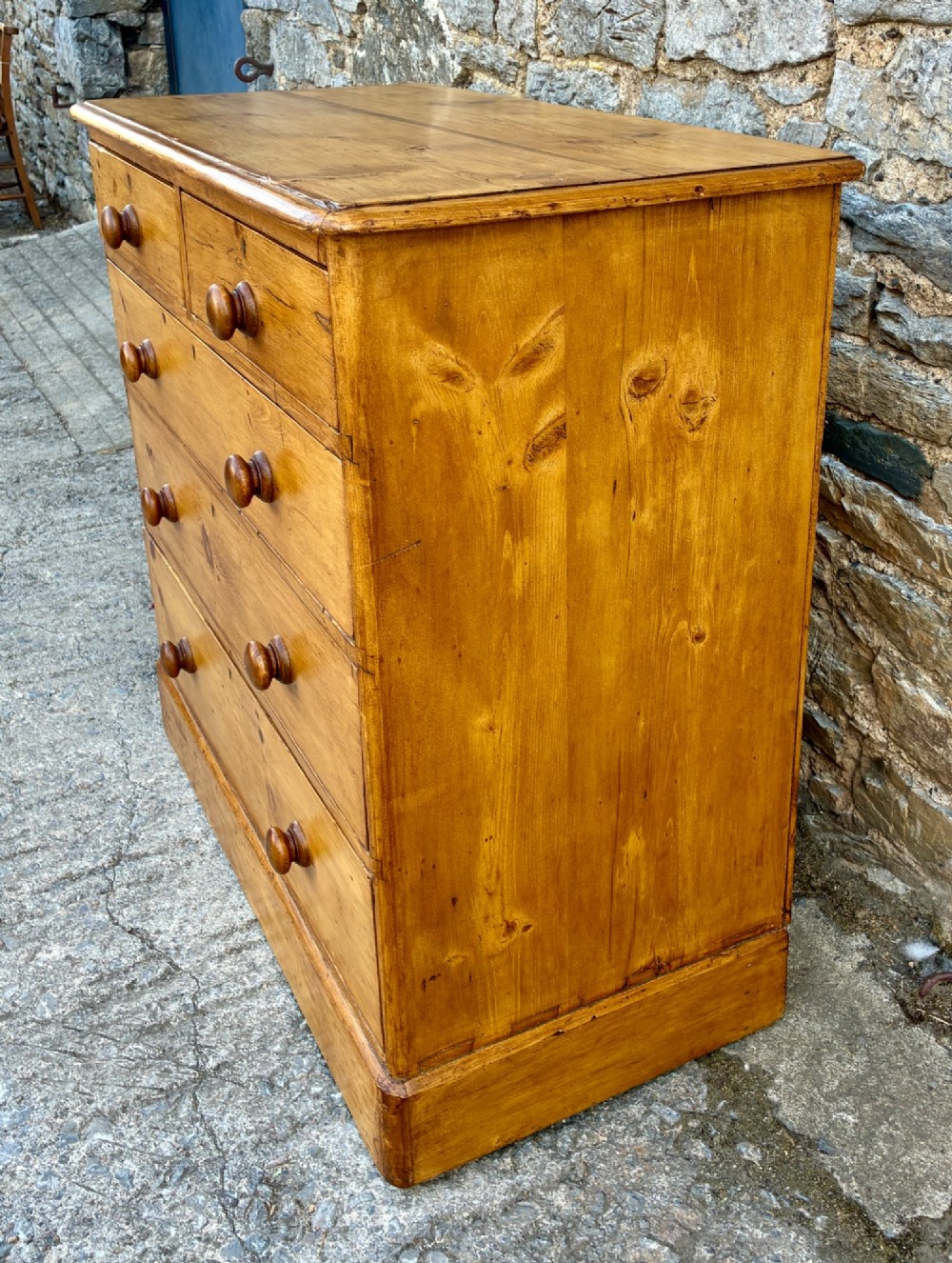 A Victorian pine chest of drawers featuring a two short over three long drawer arrangement with turned wooden knobs. View VI