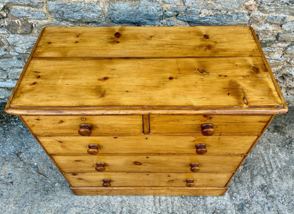 A Victorian pine chest of drawers featuring a two short over three long drawer arrangement with turned wooden knobs. View VII