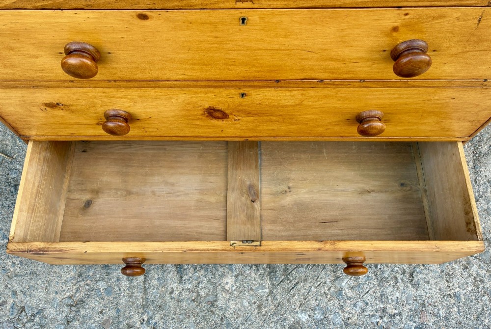 A Victorian pine chest of drawers featuring a two short over three long drawer arrangement with turned wooden knobs. View IX