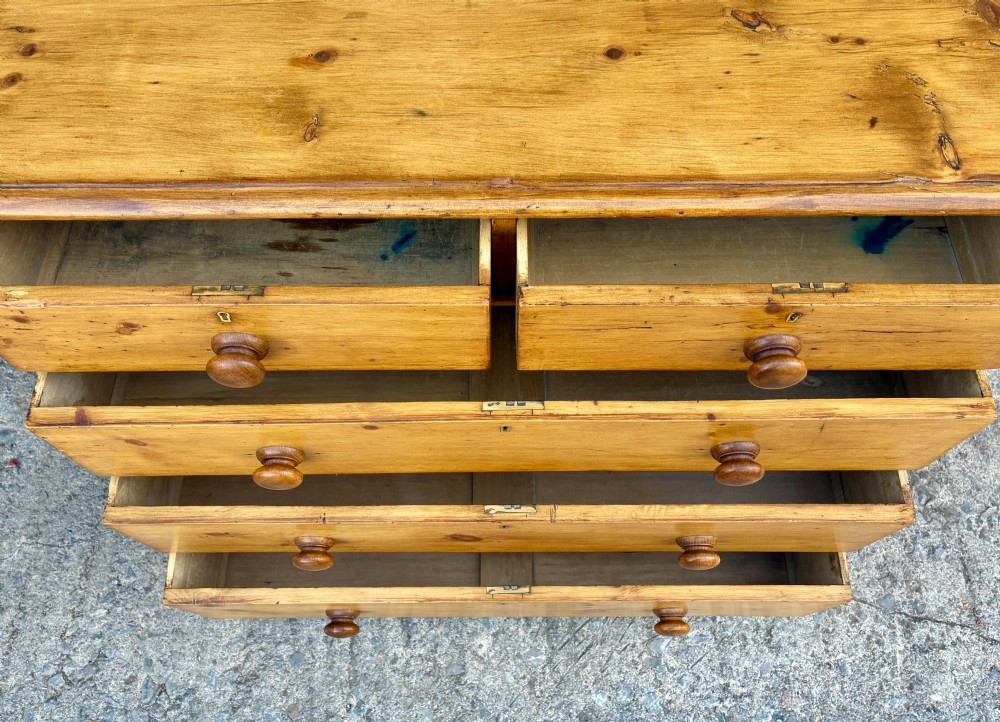 A Victorian pine chest of drawers featuring a two short over three long drawer arrangement with turned wooden knobs. View X