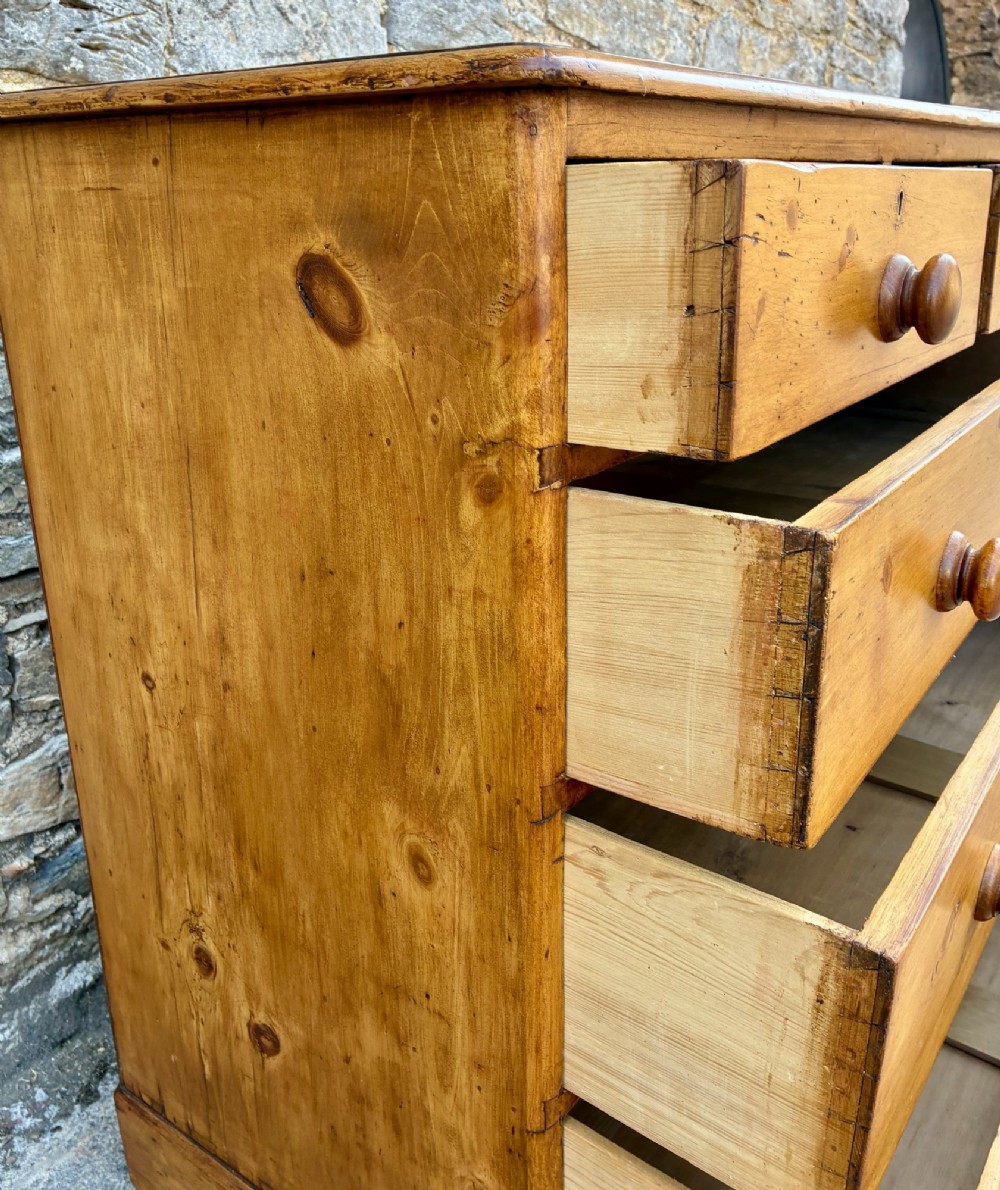 A Victorian pine chest of drawers featuring a two short over three long drawer arrangement with turned wooden knobs. View XI