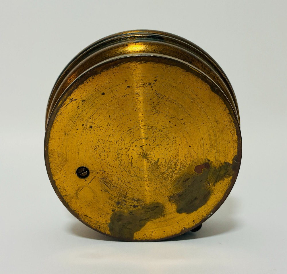 A circular antique brass wall barometer with a cream dial displaying weather conditions and an integrated glass tube thermometer. View IX