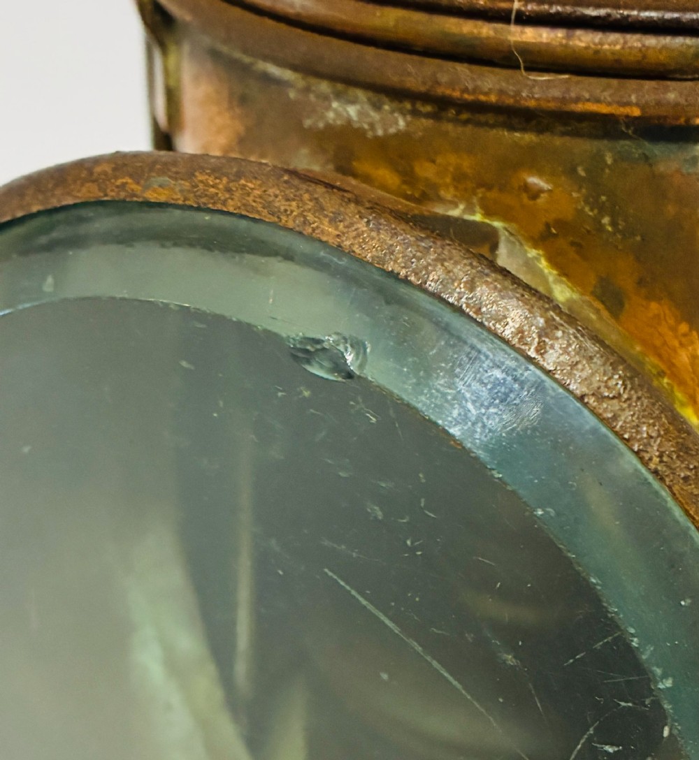 An antique metal railway signalling lamp with an arched top carrying handle, a conical vented cap, and a prominent circular glass lens. View VIII