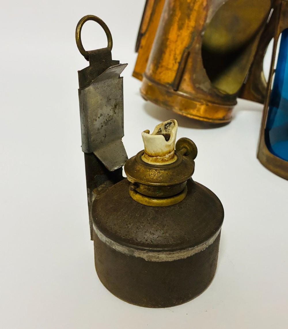 An antique metal railway signalling lamp with an arched top carrying handle, a conical vented cap, and a prominent circular glass lens. View XII
