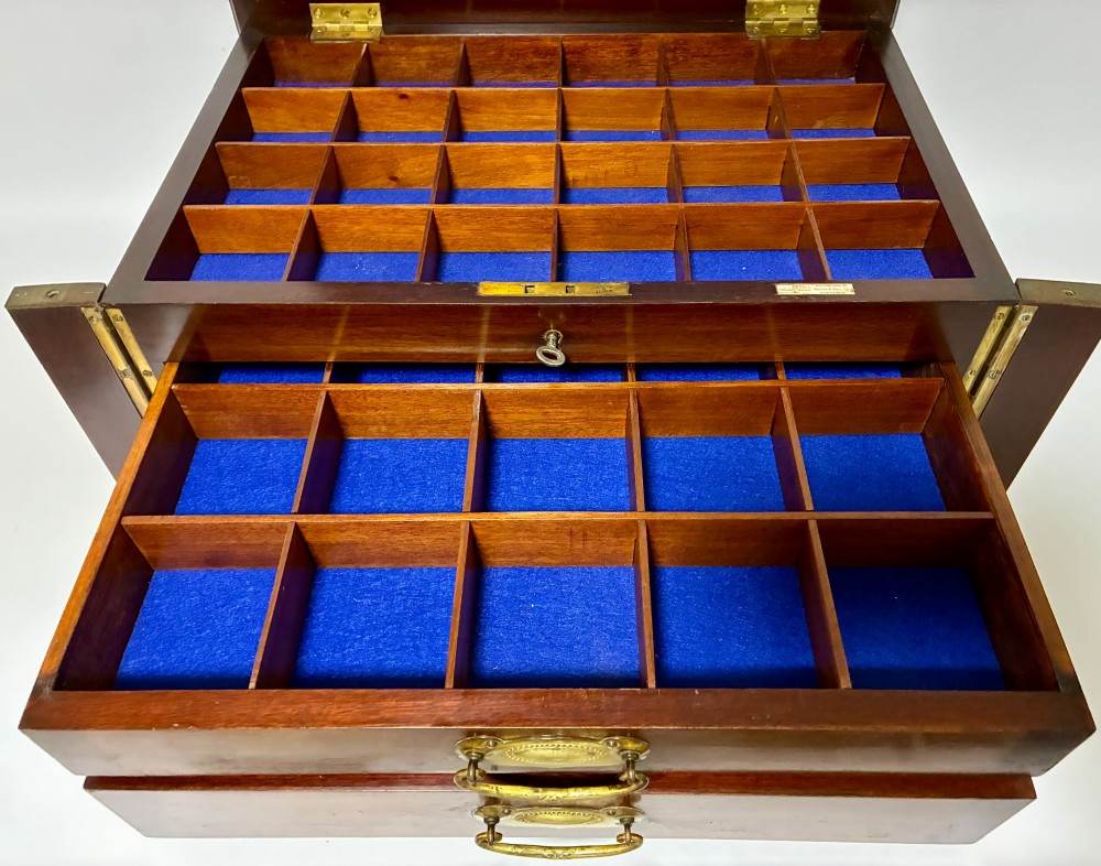 An Edwardian warm brown mahogany collectors box featuring wood inlay, brass drop handles, and a polished lid. View V