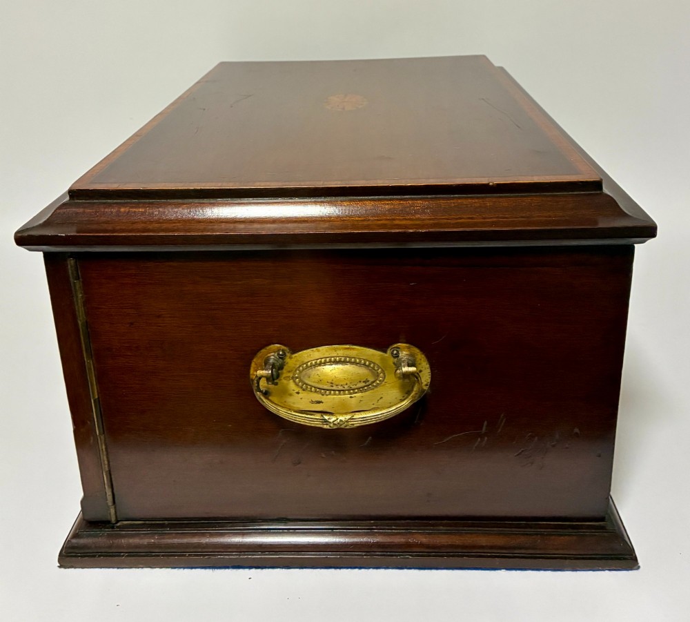 An Edwardian warm brown mahogany collectors box featuring wood inlay, brass drop handles, and a polished lid. View IX