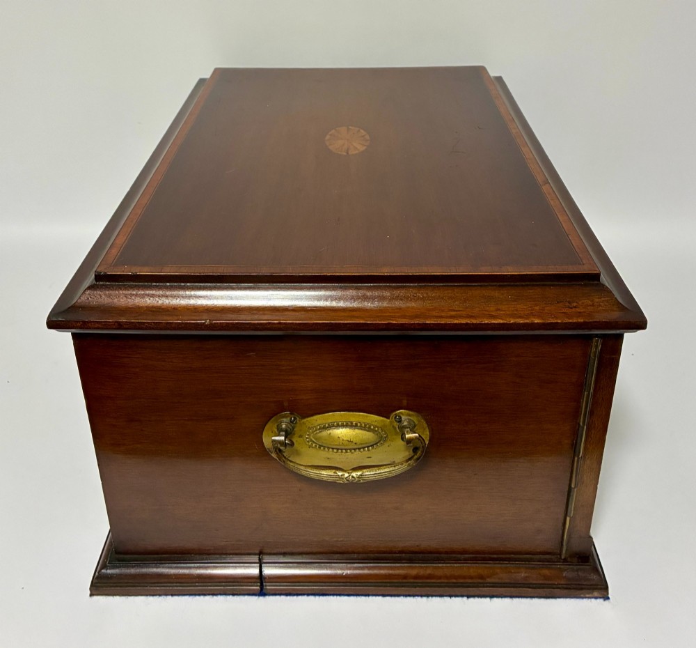 An Edwardian warm brown mahogany collectors box featuring wood inlay, brass drop handles, and a polished lid. View XI