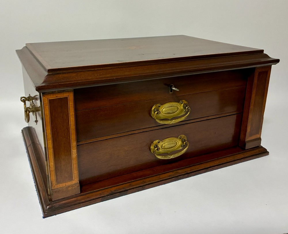 An Edwardian warm brown mahogany collectors box featuring wood inlay, brass drop handles, and a polished lid. View XIII