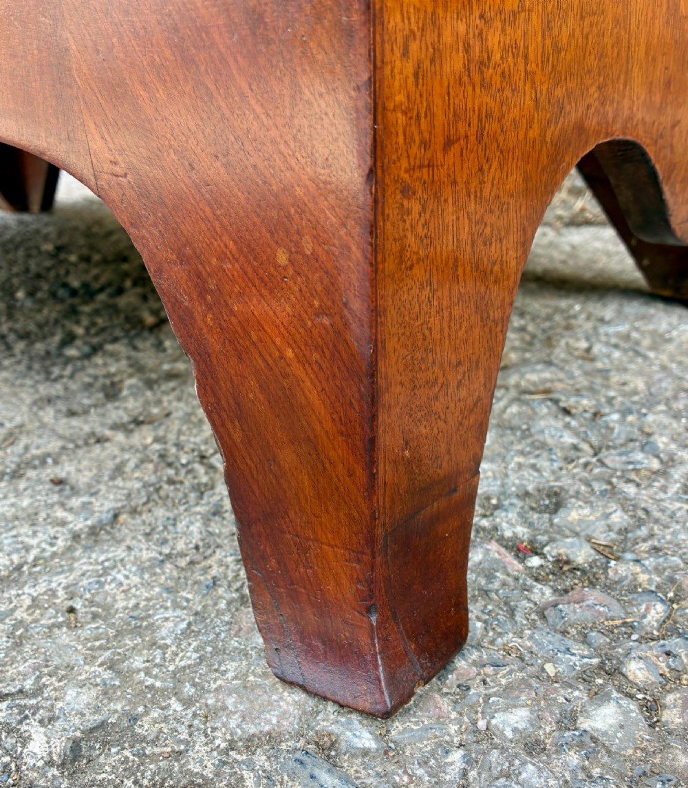 An antique Regency mahogany chest of drawers featuring a curved bowfront shape, three drawers with oval brass handles, and splayed bracket feet. View XII