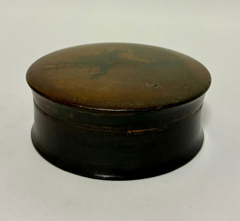 A circular Georgian papier-mache table snuff box featuring a hand-painted depiction of a gentleman in a top hat and tailcoat against a dark lacquered background. View IV