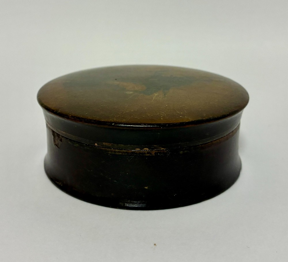 A circular Georgian papier-mache table snuff box featuring a hand-painted depiction of a gentleman in a top hat and tailcoat against a dark lacquered background. View VI