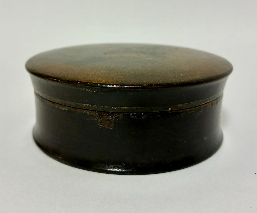A circular Georgian papier-mache table snuff box featuring a hand-painted depiction of a gentleman in a top hat and tailcoat against a dark lacquered background. View VII