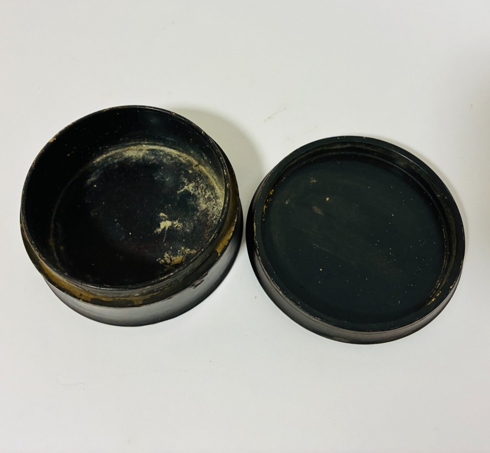 A circular Georgian papier-mache table snuff box featuring a hand-painted depiction of a gentleman in a top hat and tailcoat against a dark lacquered background. View IX
