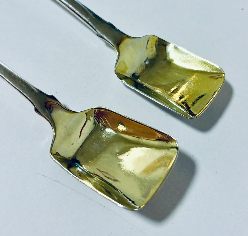 A pair of Georgian silver salt shovels featuring rectangular silver-gilt shovel bowls and smooth fiddle pattern handles. View V