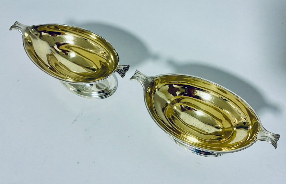 A pair of Georgian sterling silver boat-shaped salt cellars with pedestal bases and gilded interiors. View III