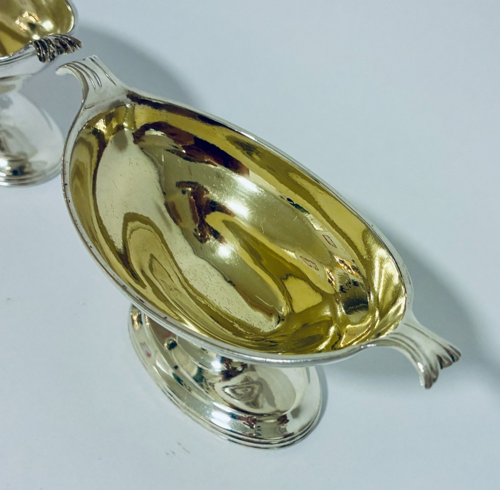 A pair of Georgian sterling silver boat-shaped salt cellars with pedestal bases and gilded interiors. View IV