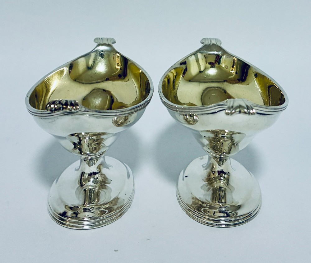 A pair of Georgian sterling silver boat-shaped salt cellars with pedestal bases and gilded interiors. View VII