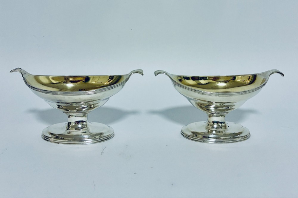 A pair of Georgian sterling silver boat-shaped salt cellars with pedestal bases and gilded interiors. View VIII