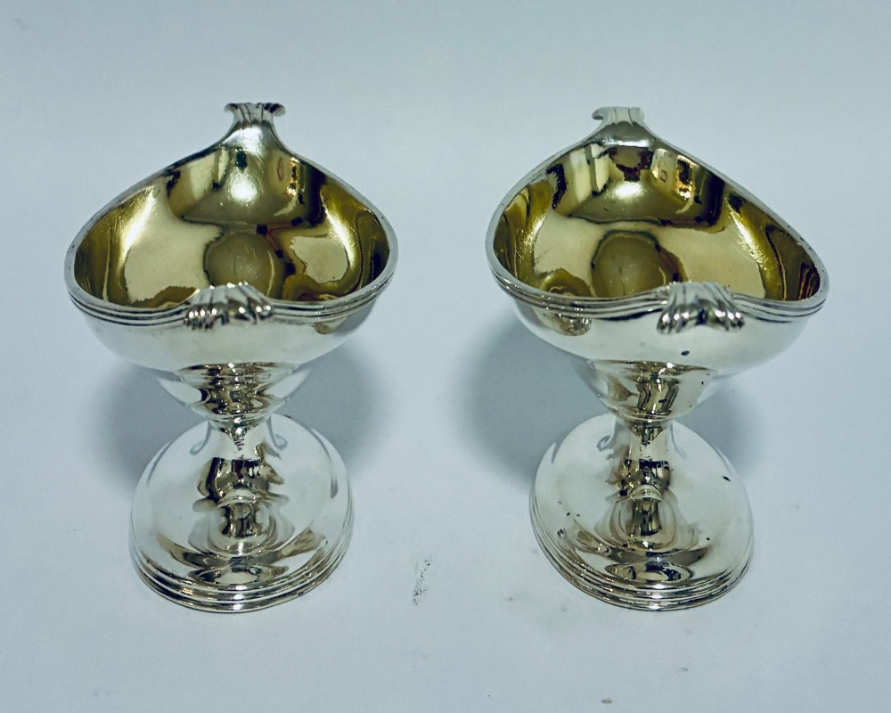 A pair of Georgian sterling silver boat-shaped salt cellars with pedestal bases and gilded interiors. View IX