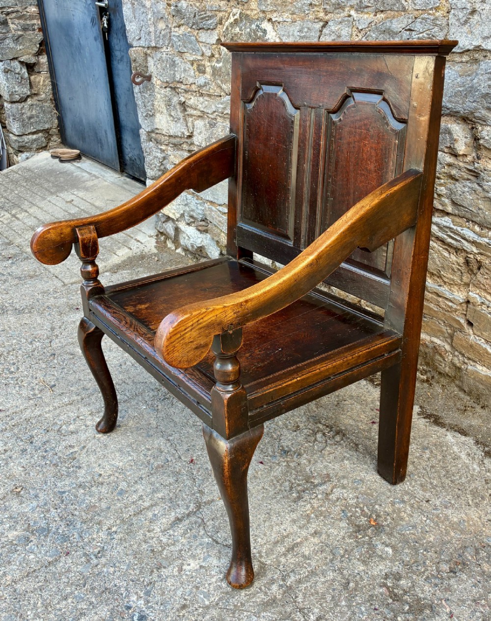 An 18th-century Georgian dark oak settle featuring a twin arched-panel back, contoured armrests, and cabriole front legs. View VI