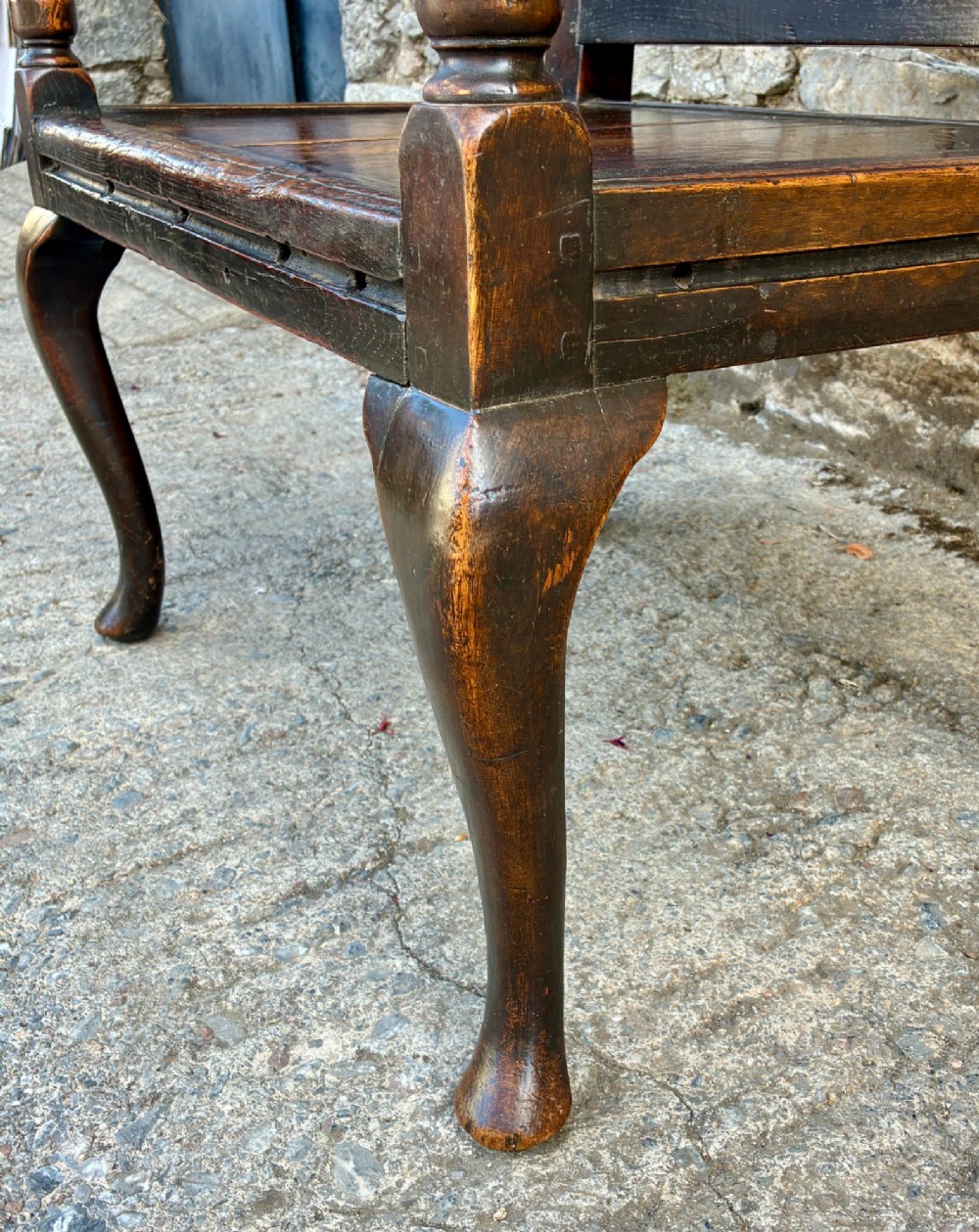An 18th-century Georgian dark oak settle featuring a twin arched-panel back, contoured armrests, and cabriole front legs. View VII