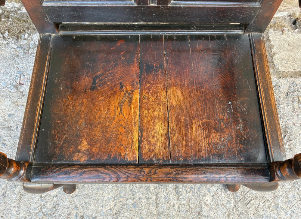 An 18th-century Georgian dark oak settle featuring a twin arched-panel back, contoured armrests, and cabriole front legs. View VIII