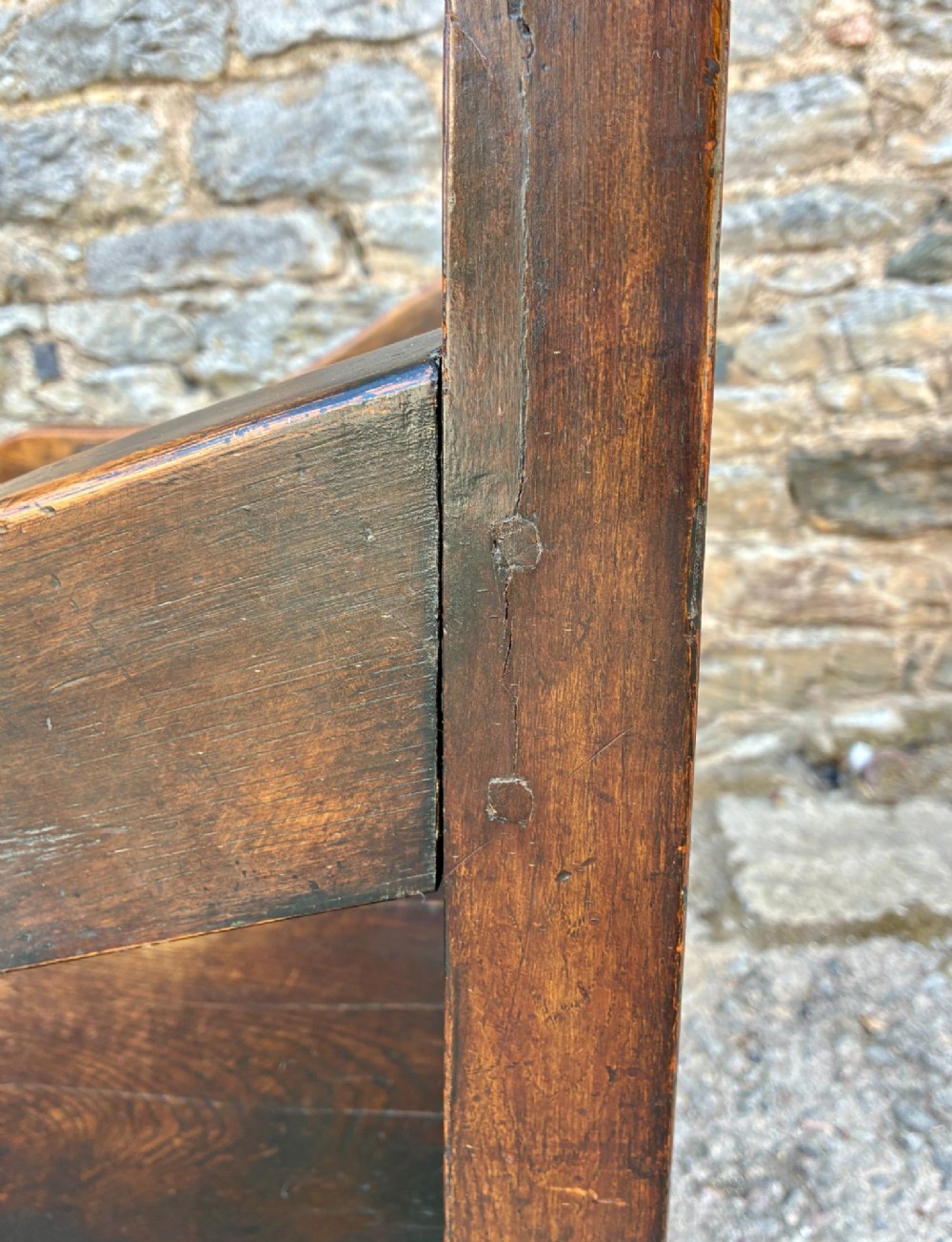 An 18th-century Georgian dark oak settle featuring a twin arched-panel back, contoured armrests, and cabriole front legs. View XIV