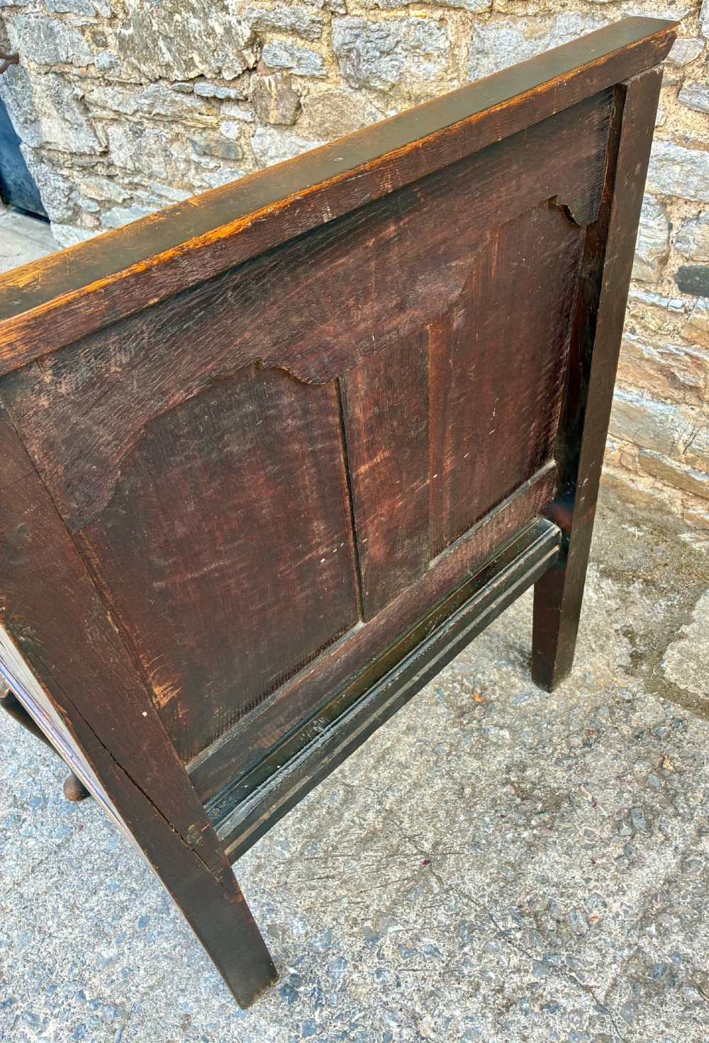 An 18th-century Georgian dark oak settle featuring a twin arched-panel back, contoured armrests, and cabriole front legs. View XV