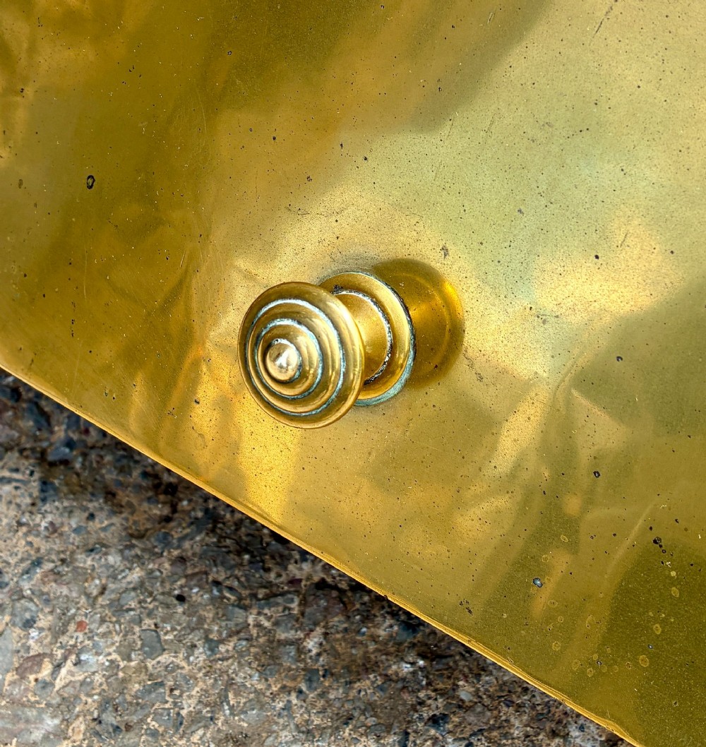 An antique brass sloped coal scuttle featuring a turned wooden carrying handle, a hinged lid, and an attached brass shovel at the rear. View IX