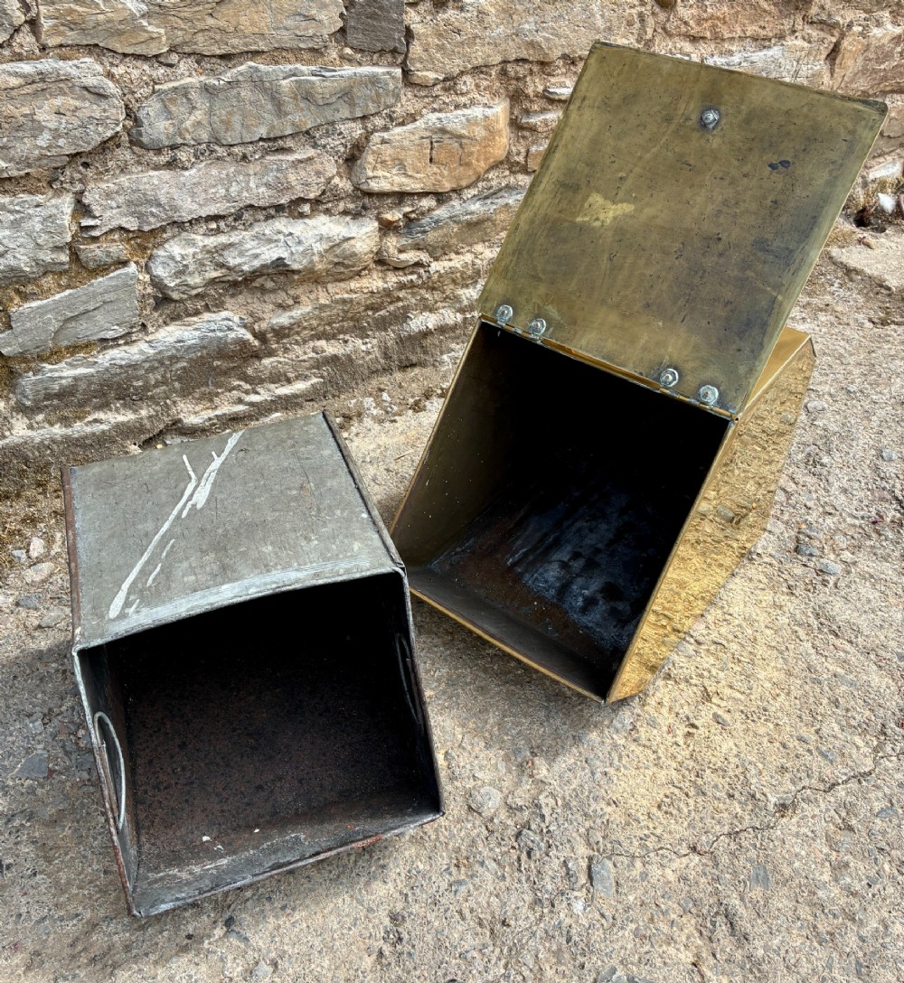 An antique brass sloped coal scuttle featuring a turned wooden carrying handle, a hinged lid, and an attached brass shovel at the rear. View XII