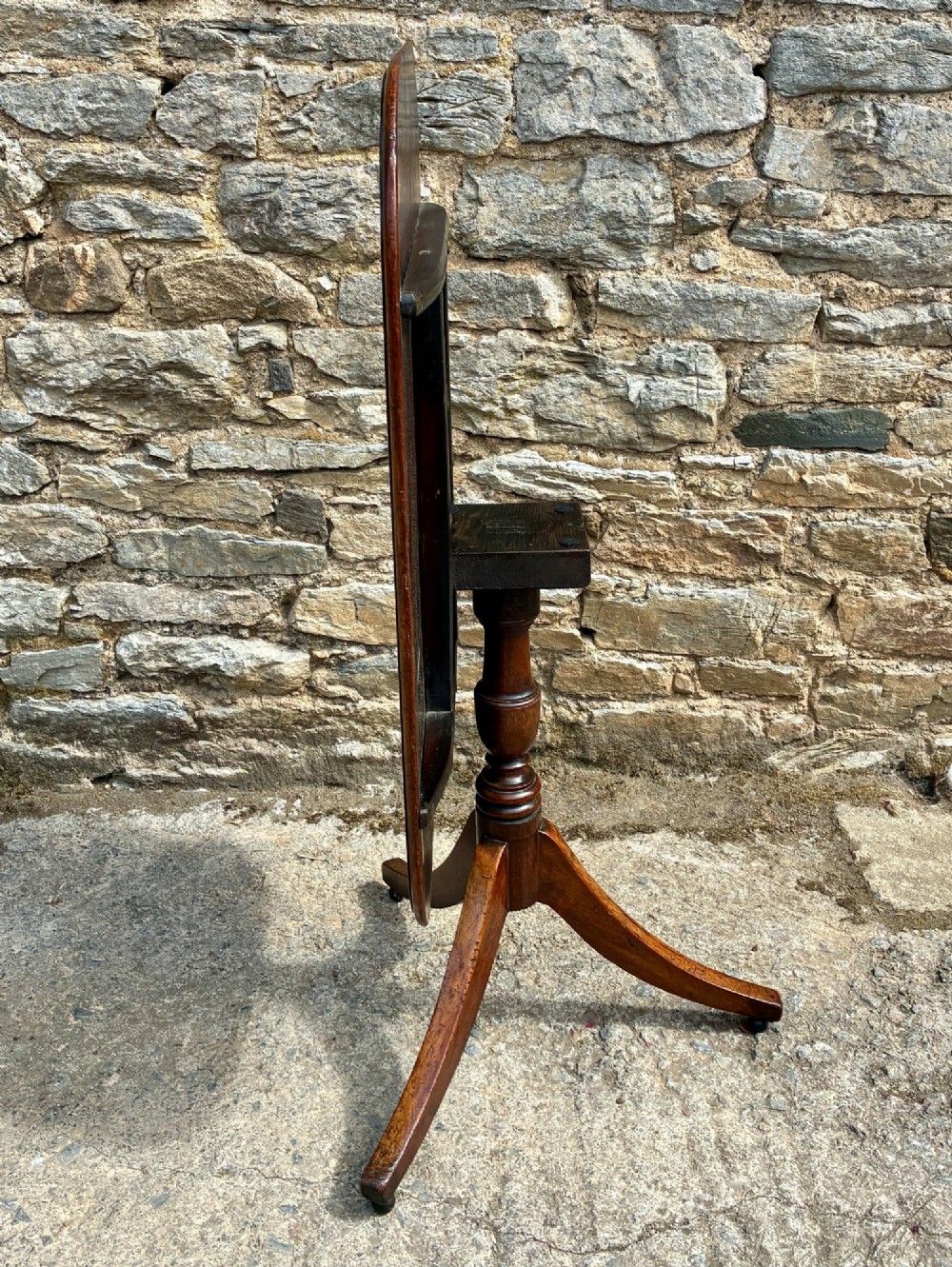 A Victorian mahogany tilt-top table featuring a polished rounded rectangular surface set on a turned pedestal column with three splayed legs. View VII