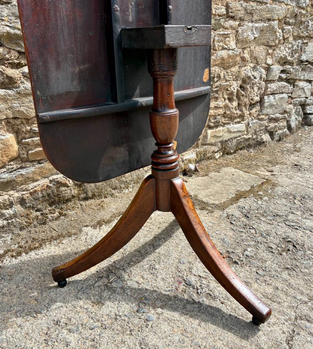 A Victorian mahogany tilt-top table featuring a polished rounded rectangular surface set on a turned pedestal column with three splayed legs. View IX