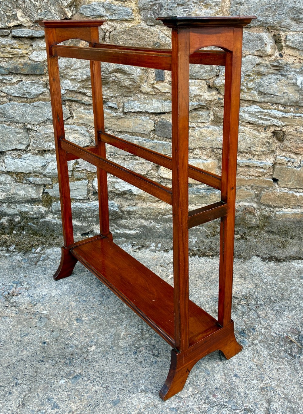 An Edwardian mahogany freestanding towel rail featuring double horizontal bars, a lower solid wooden shelf, vertical side supports, and flared feet. View IX