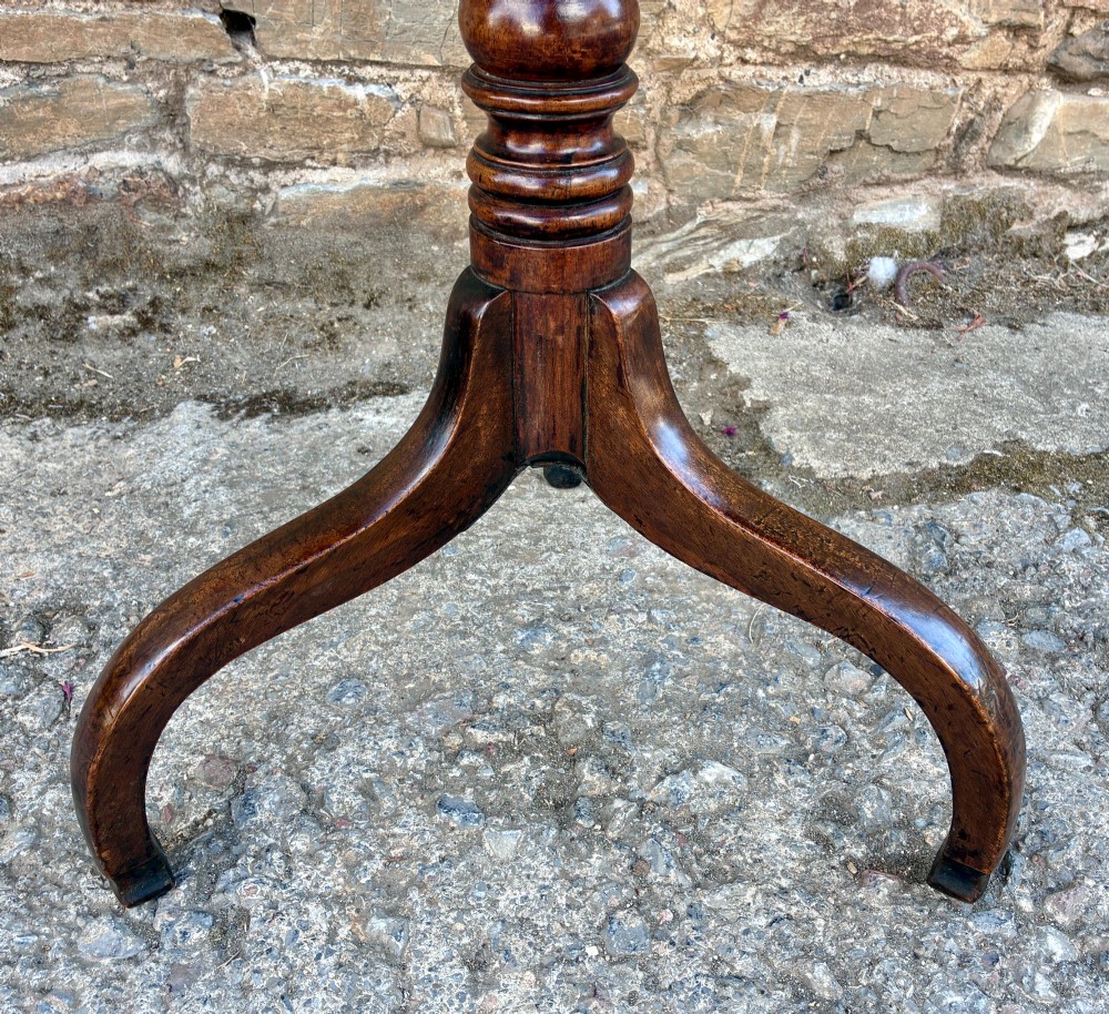 An antique Regency mahogany wine table featuring a circular top, turned pedestal stem, and three cabriole tripod legs. View VI