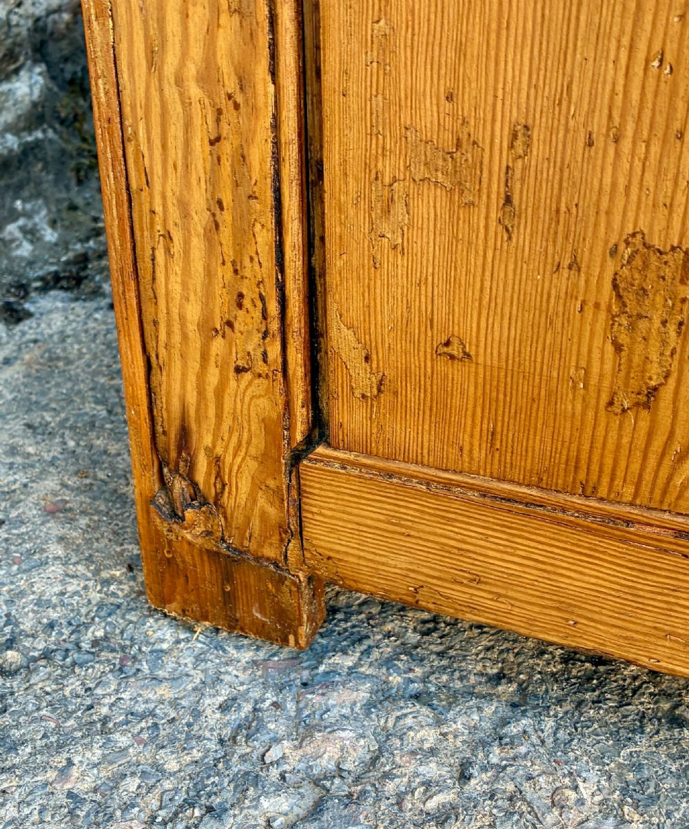 A nineteenth-century pine dresser base featuring three top drawers, three lower panelled cupboard doors, and turned dark wooden knobs. View XIV