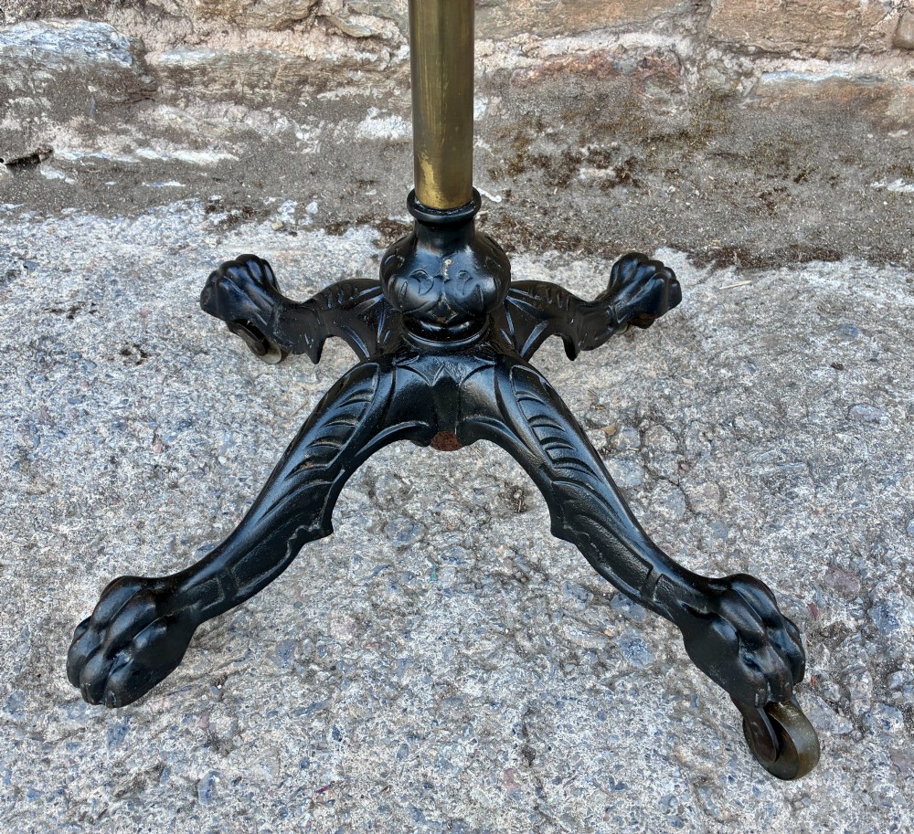 Victorian adjustable display stand featuring a round mahogany top, a brass telescoping stem, and a black cast iron paw-foot base. View III