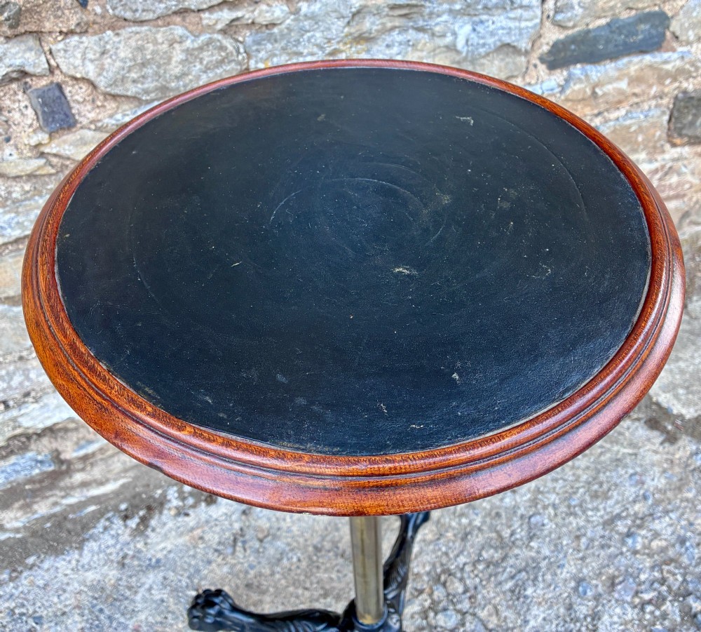 Victorian adjustable display stand featuring a round mahogany top, a brass telescoping stem, and a black cast iron paw-foot base. View VI