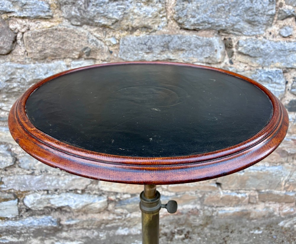 Victorian adjustable display stand featuring a round mahogany top, a brass telescoping stem, and a black cast iron paw-foot base. View VII