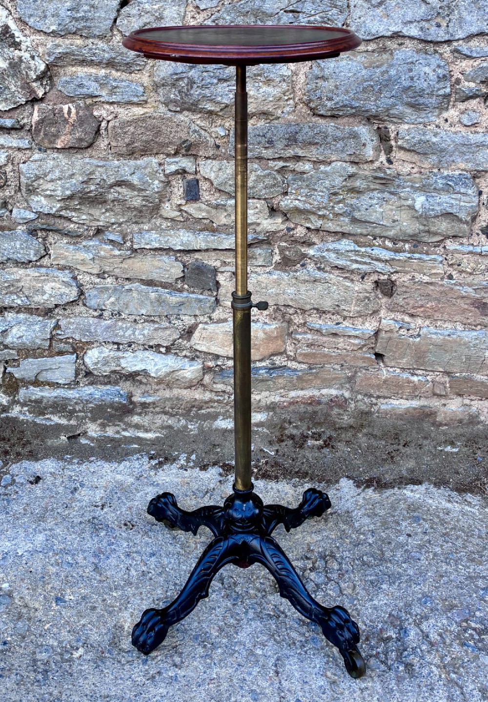 Victorian adjustable display stand featuring a round mahogany top, a brass telescoping stem, and a black cast iron paw-foot base. View IX