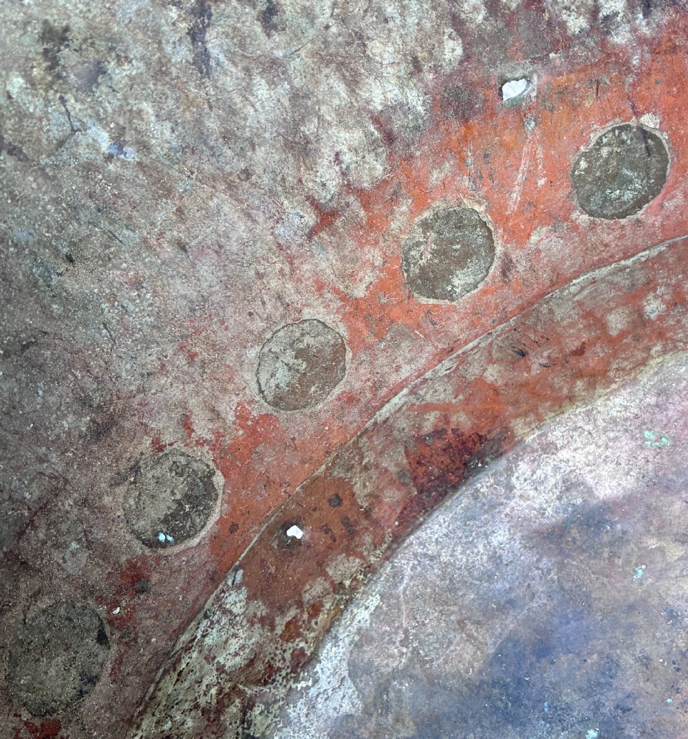 A large round copper boiler with a hand-riveted base seam and flared rim, supported on four decorative cast brass claw feet. View VIII