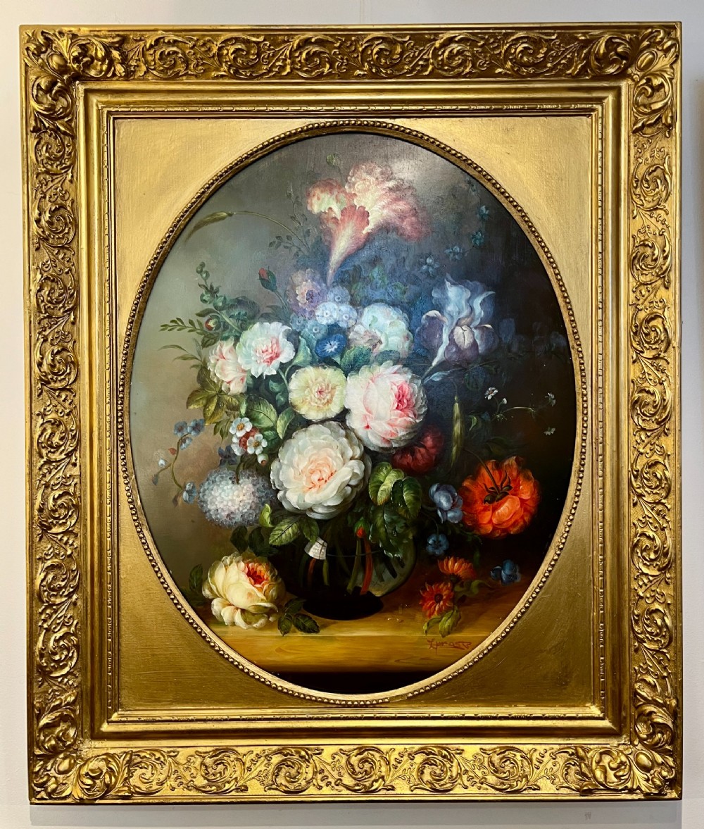 A pair of oil paintings on board featuring floral bouquets framed within oval apertures inside ornate gold frames. View II