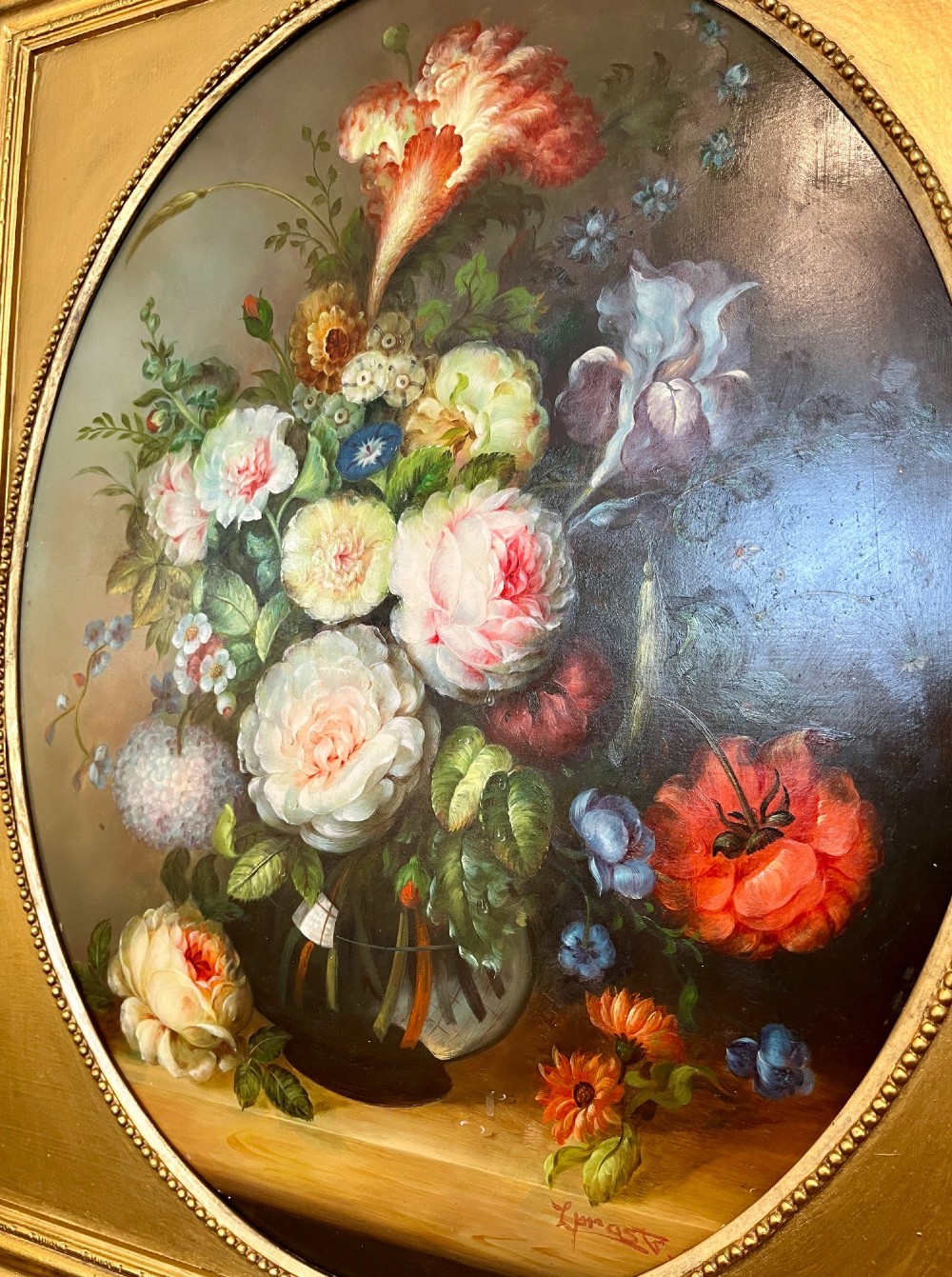 A pair of oil paintings on board featuring floral bouquets framed within oval apertures inside ornate gold frames. View V
