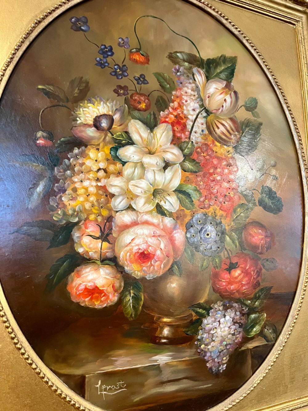 A pair of oil paintings on board featuring floral bouquets framed within oval apertures inside ornate gold frames. View IX
