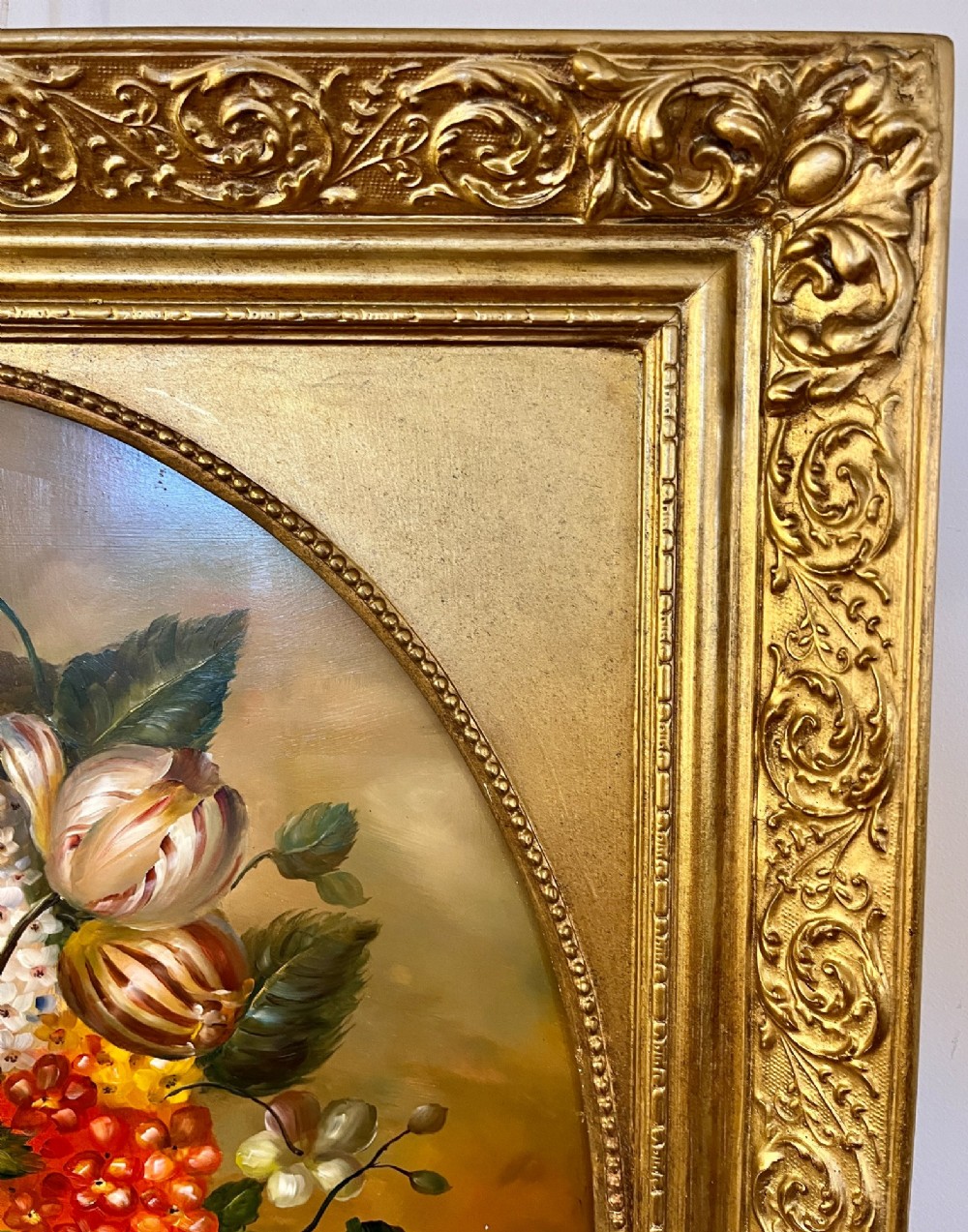 A pair of oil paintings on board featuring floral bouquets framed within oval apertures inside ornate gold frames. View XII
