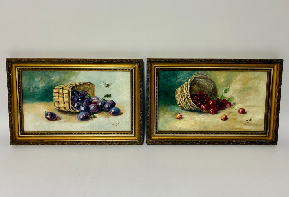 A pair of rectangular oil paintings depicting plums and cherries spilling from woven baskets in gilt wood frames.