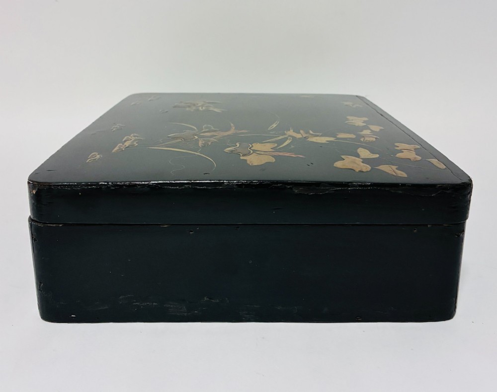 A rectangular black lacquered box decorated with gold maki-e depictions of rabbits and foliage, featuring a central metal keyhole. View VI