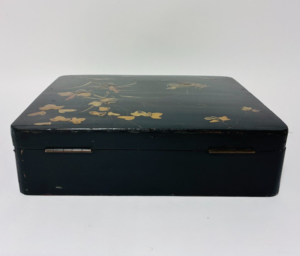 A rectangular black lacquered box decorated with gold maki-e depictions of rabbits and foliage, featuring a central metal keyhole. View VIII