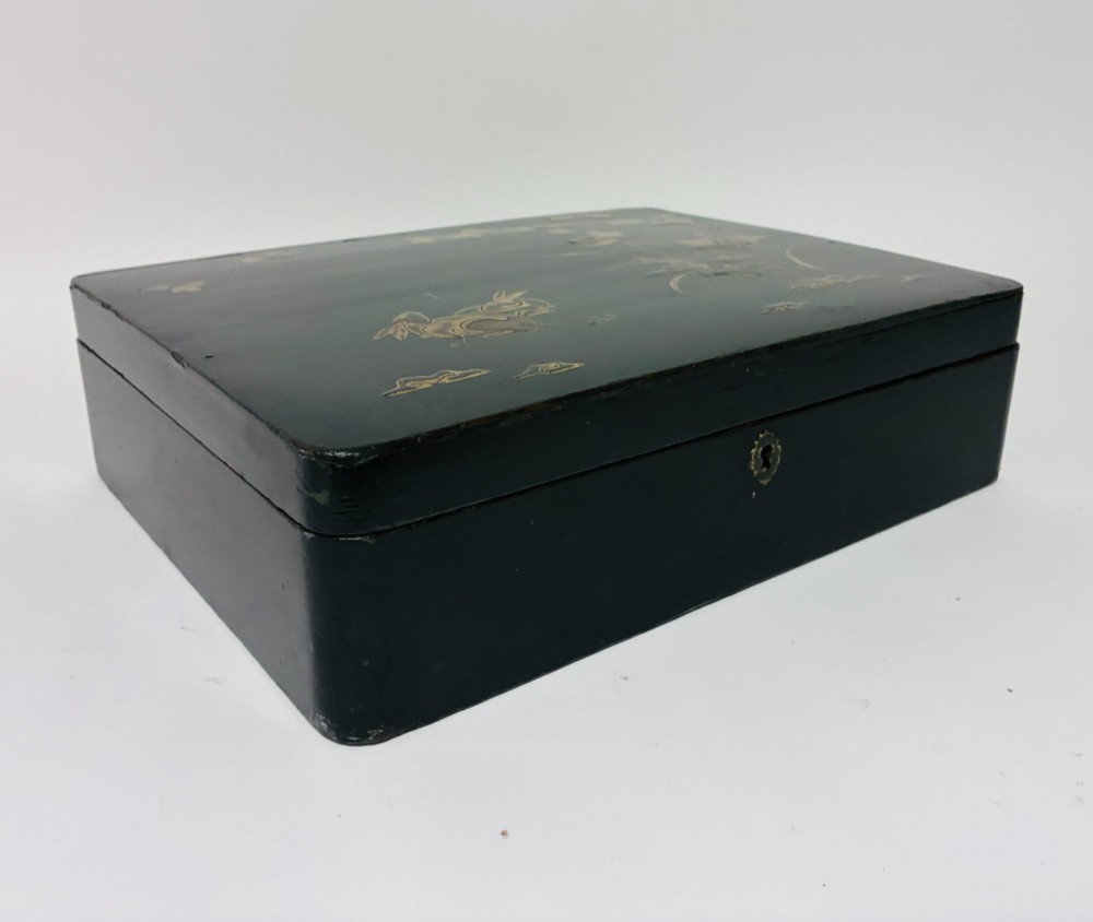 A rectangular black lacquered box decorated with gold maki-e depictions of rabbits and foliage, featuring a central metal keyhole. View XI