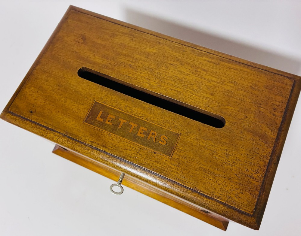 An antique mahogany tabletop letter box featuring a top posting slot, carved LETTERS plaque, key lock mechanism, and bevelled glass front panel. View II